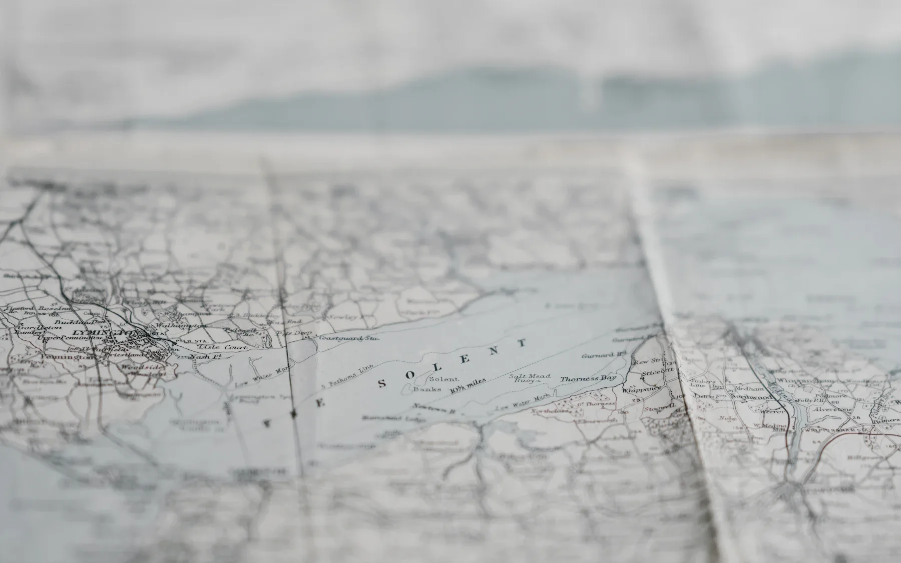 A vintage paper map of the Solent spread across a table.
